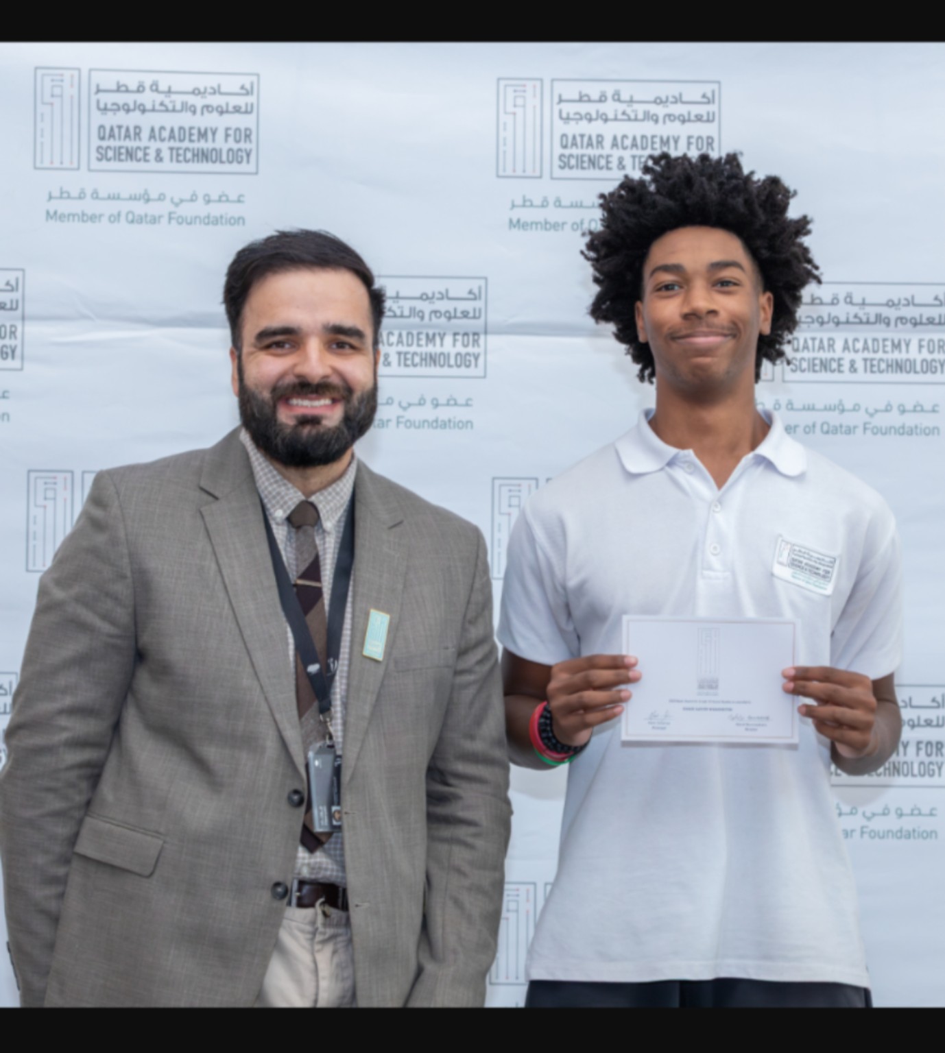Chase holding a certificate at Qatar Academy