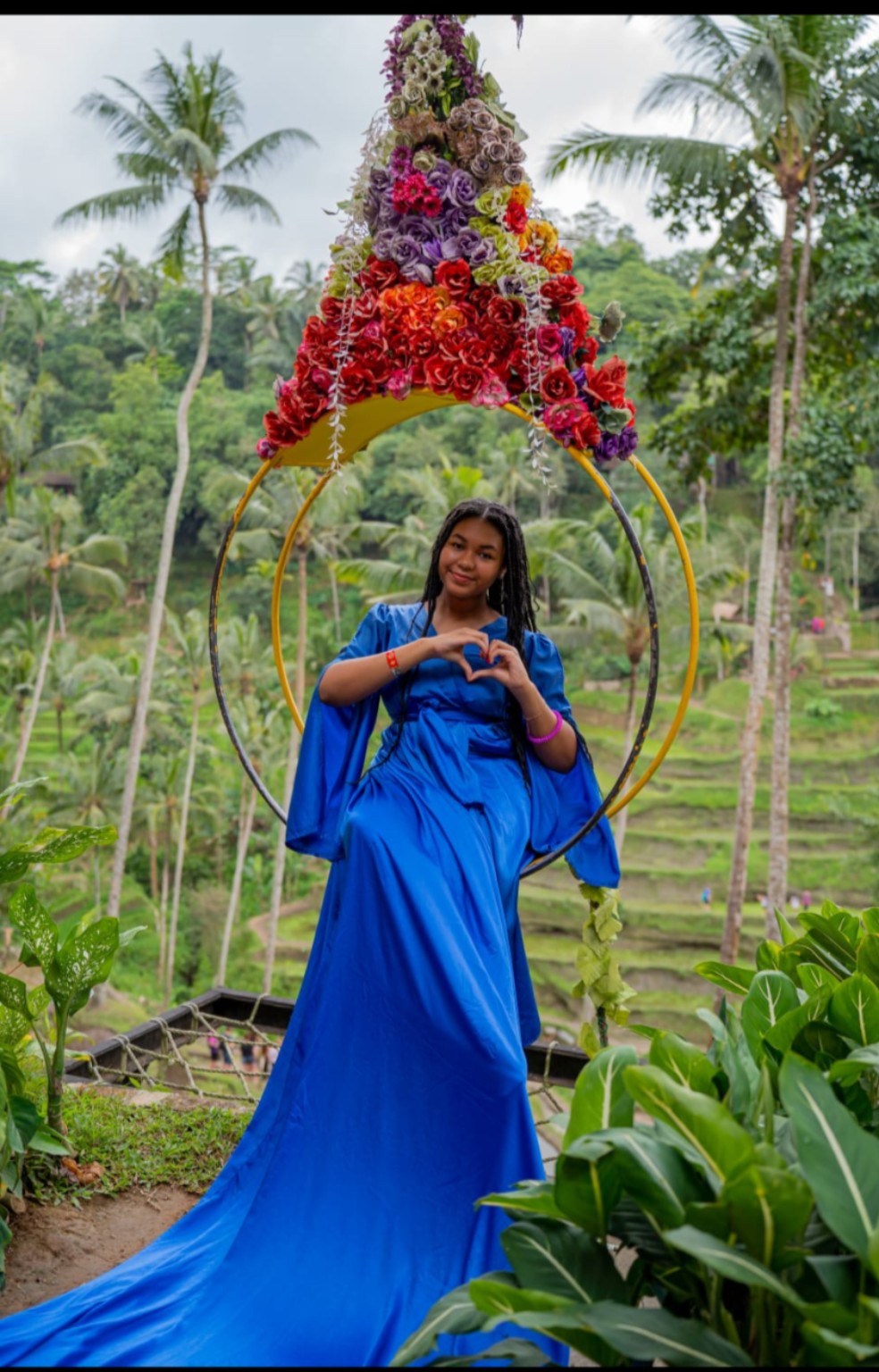 Kelsie in a blue dress in a lush tropical setting