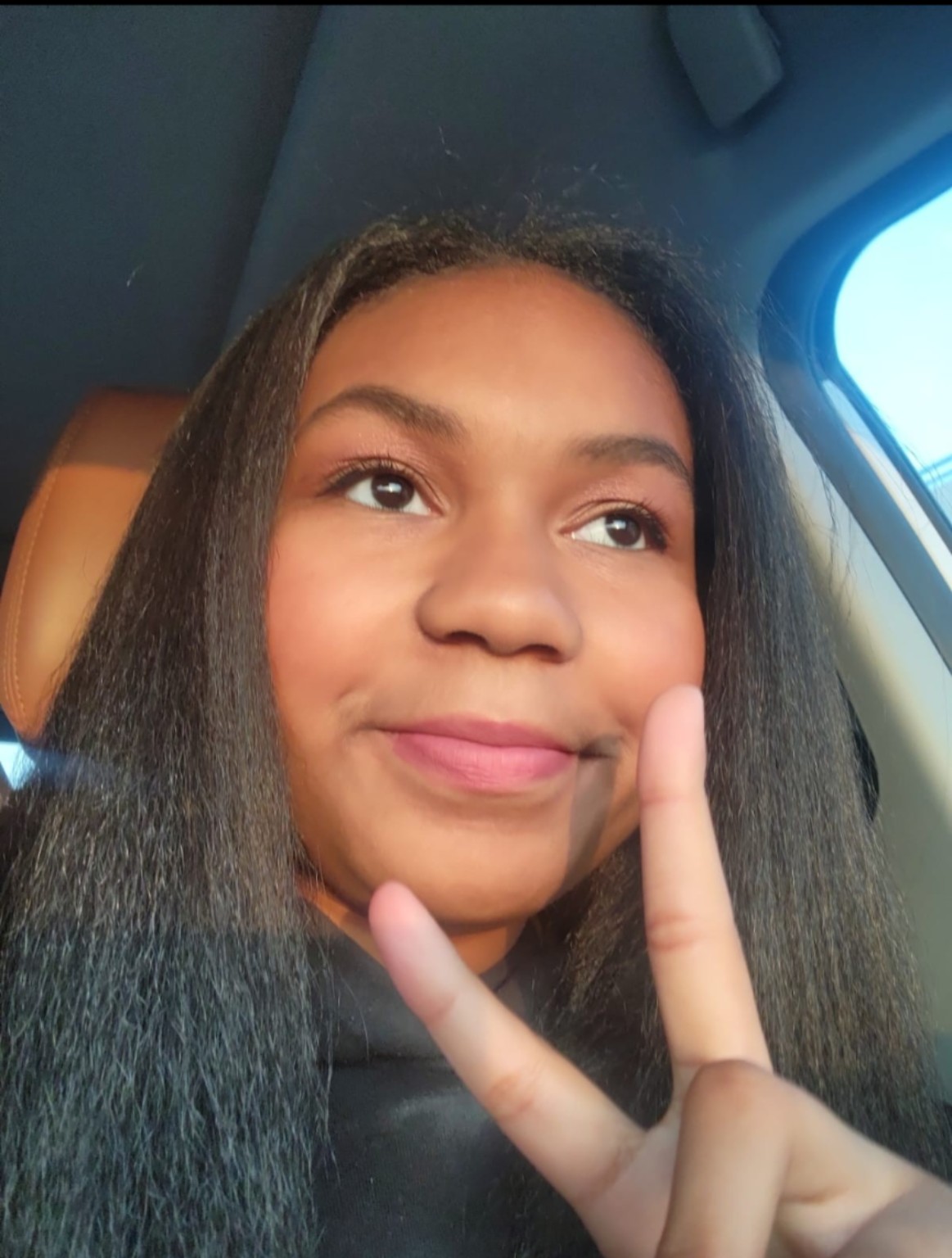 Kelsie smiling and giving a peace sign